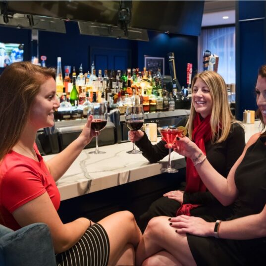 tree women at the bar making a toast
